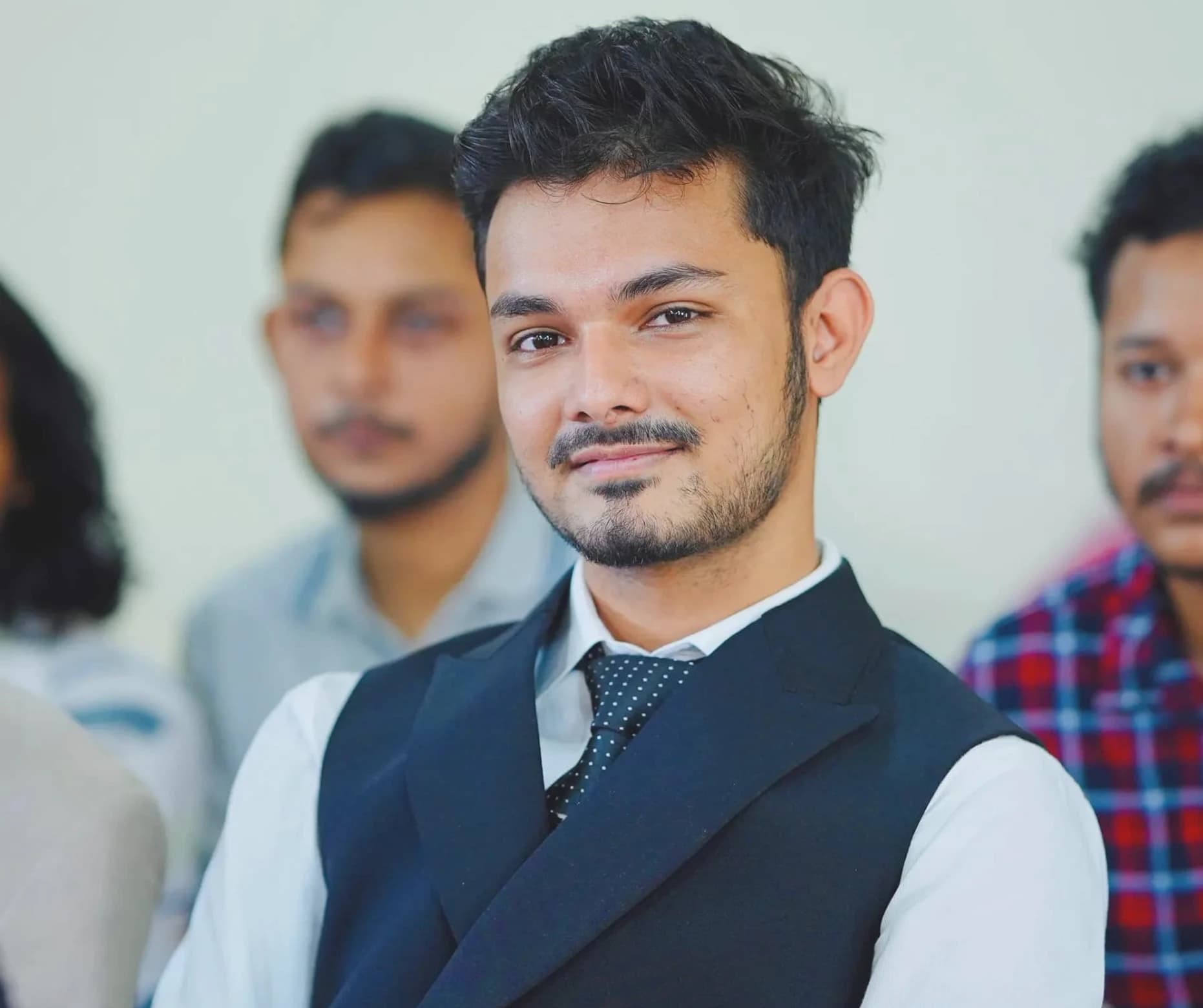 Redwan Ahmed wearing a navy waistcoat and tie
